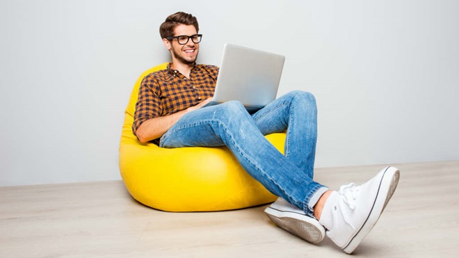 Man using laptop while sitting on beanbag